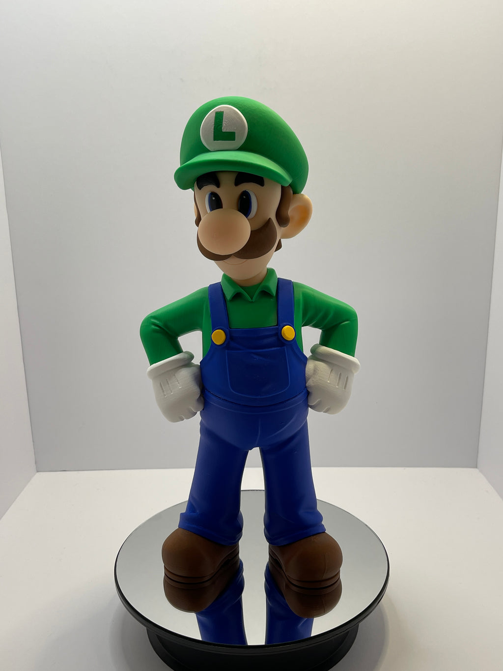 Front view of video game figurine with green cap and blue overalls